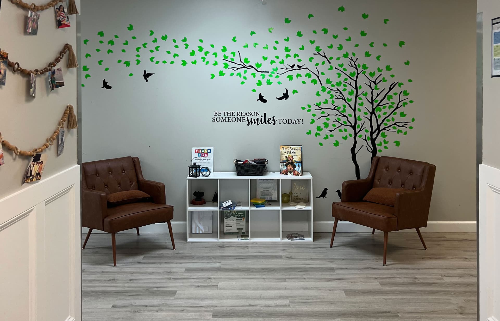 The Ashburn lobby with two armchairs beside a painted tree mural reading “Be the reason someone smiles today!”